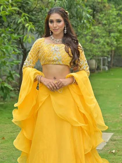 A full-length shot of a model in a flowing yellow outfit. This look is perfect for a daytime event, showing the versatility of my jewellery collection beyond just bridal wear.