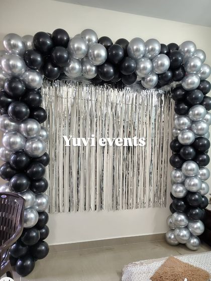 Another example of the black and silver balloon arch with a foil curtain, showing how it can frame a space for photos.