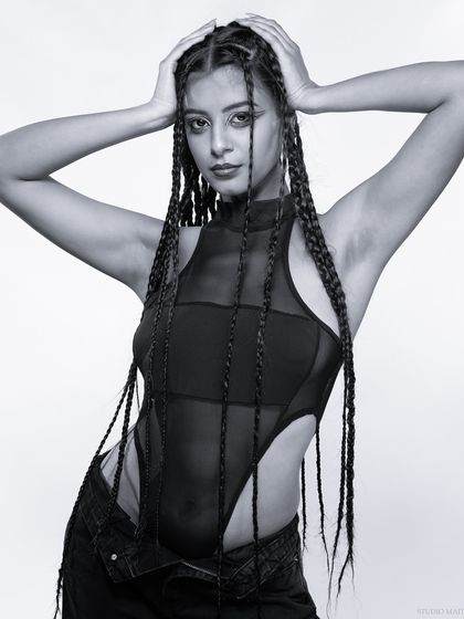 A powerful pose in black and white, with the model's hands behind her head.