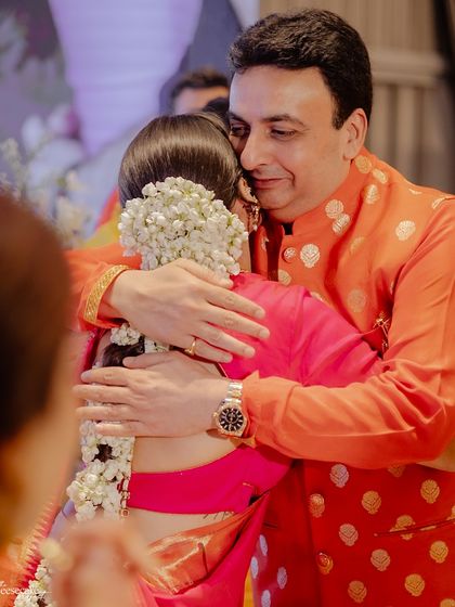 A warm hug from behind, a father embracing his daughter on her wedding day.