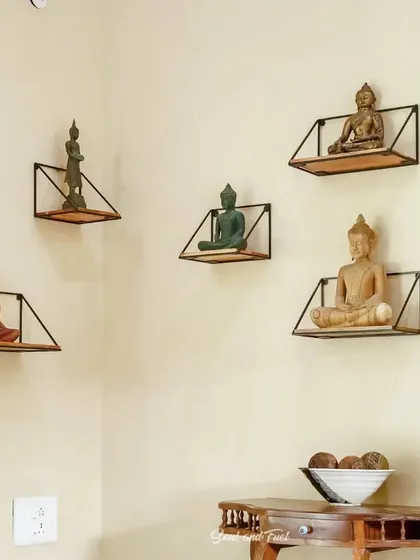 A gallery wall featuring a collection of Buddha statues on minimalist shelves. This serene and spiritual corner at Villa Magnolia, Coorg, creates a peaceful and contemplative atmosphere.