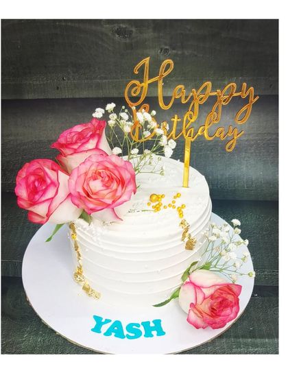 An elegant cake with fresh pink and white roses. This fresh pineapple cake is perfect for a sophisticated birthday celebration.