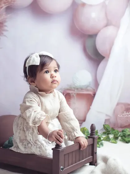 A pensive moment for the birthday girl. This dreamy, soft-hued setup creates a beautiful, ethereal portrait for her first birthday.