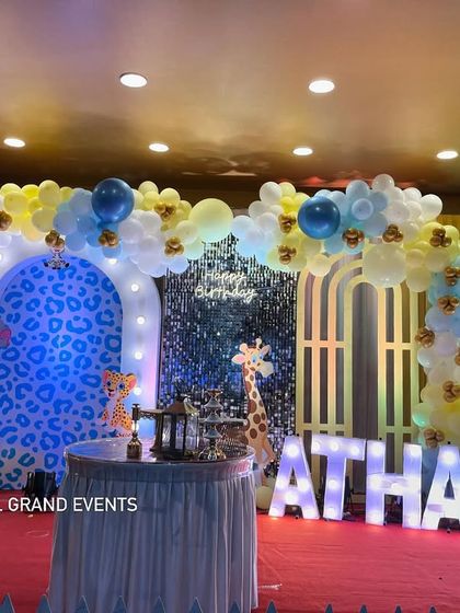 A clear, front-on shot of the stage for Atharva's first birthday, highlighting the marquee '1' and the friendly animal characters.
