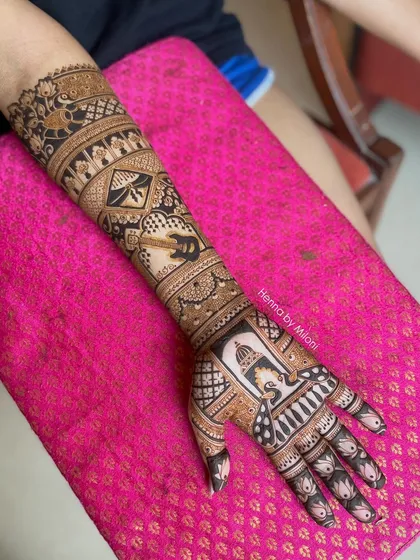 A full-arm bridal design with a mix of peacocks, kites, and architectural elements, showcasing a variety of motifs in one piece.