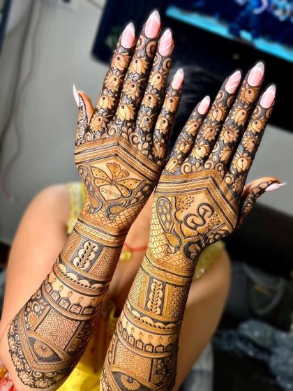 A full view of a heavy bridal mehandi design, covering both hands from the fingertips to the elbows with dense, traditional patterns for a truly grand look.