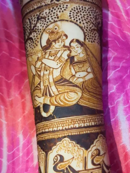 A close-up of our detailed Radha Krishna portrait work on a bride's arm. We take great care in capturing the divine expressions and intricate clothing, making it a spiritual centerpiece for your bridal henna.