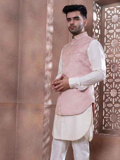 The rose pink bundi set, shown against a textured backdrop. The soft pastel tone is ideal for daytime celebrations and summer weddings, offering a sophisticated and stylish option.