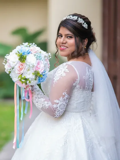 A happy bridal portrait showing off the beautiful back of her dress and her lovely bouquet. The bride's smile is infectious.