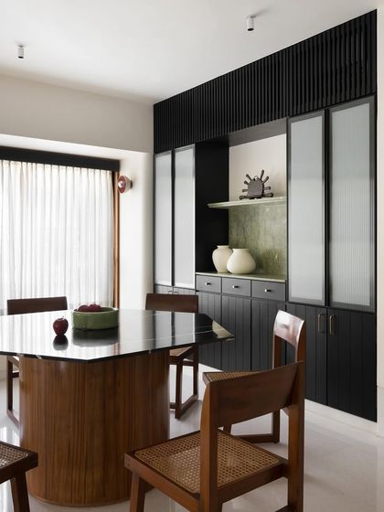 The hexagonal dining table I designed, seen here with its accompanying chairs. The dark, polished top reflects the light, adding depth and sophistication to the dining area.