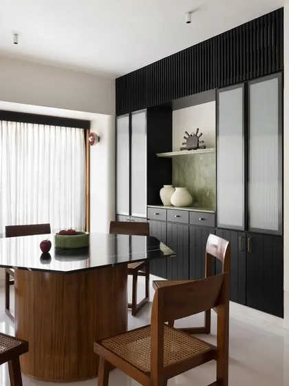 The hexagonal dining table I designed, seen here with its accompanying chairs. The dark, polished top reflects the light, adding depth and sophistication to the dining area.