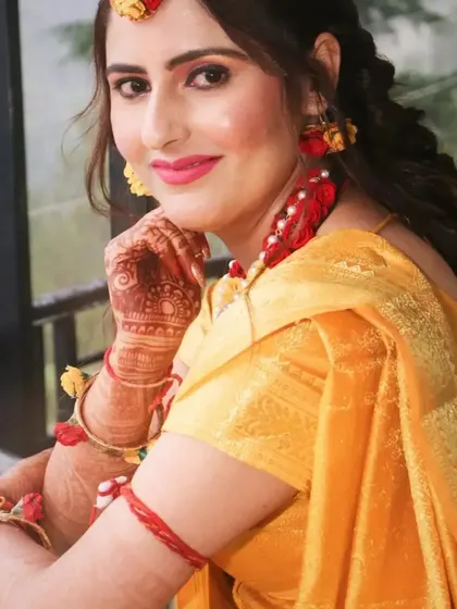 This bride is ready for her Haldi ceremony in a simple yellow saree, accessorized with beautiful floral jewelry. The makeup is kept fresh and bright with a pink lip.