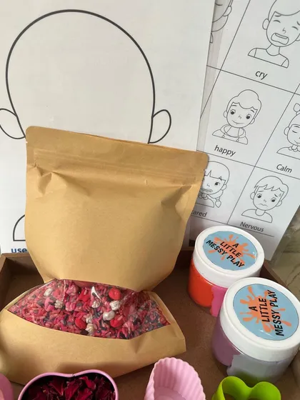 Here is a look at our complete handmade Valentine's sensory kit. It includes a bag of our taste-safe colored rice and pasta filler, two jars of our soft homemade playdough, and printed mats for learning about emotions.