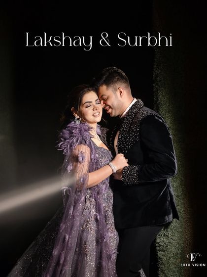A full length portrait of Lakshay and Surbhi, showcasing their coordinated, glamorous outfits. The dramatic lighting adds a cinematic quality to the image.