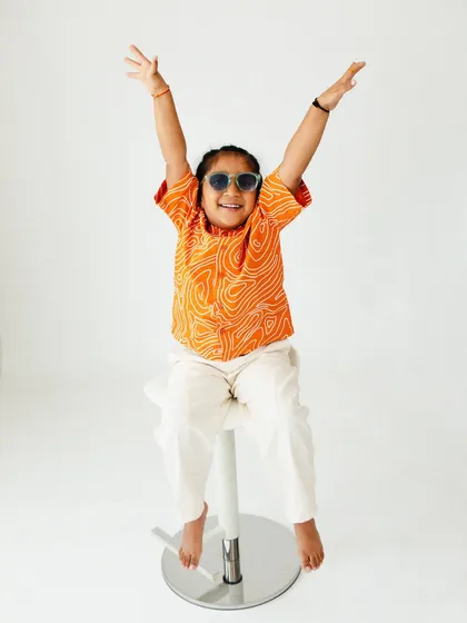 A moment of pure celebration. This toddler's joyful pose and cool sunglasses bring a fun, modern twist to his studio portrait session.