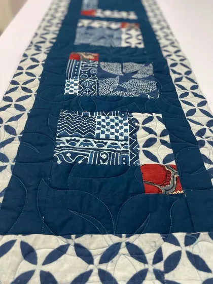 A close-up of the leaf-shaped quilting on the indigo table runner.