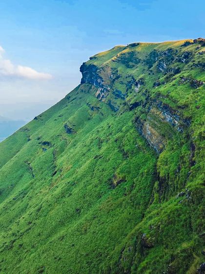 A shot of a steep, green mountain face, showing the dramatic geology of the region.