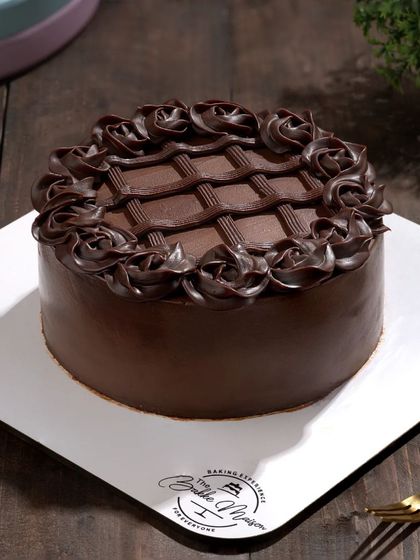 A full chocolate truffle cake with intricate piping work. We take care to light cakes in a way that shows off all the detailed decoration.