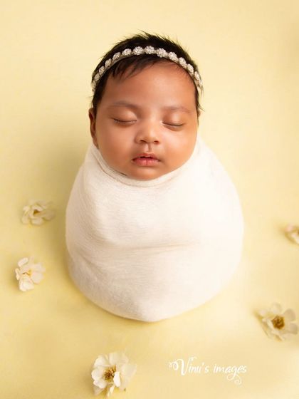 A minimalist portrait using a simple swaddle and a soft, solid color background. This style creates a timeless image that emphasizes the baby's perfect form.