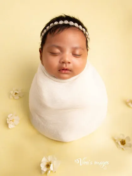 A minimalist portrait using a simple swaddle and a soft, solid color background. This style creates a timeless image that emphasizes the baby's perfect form.