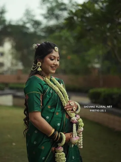 A serene portrait of a mom-to-be wearing a traditional Tagar bud necklace with lotus bud accents, paired with a matching floral hair accessory.
