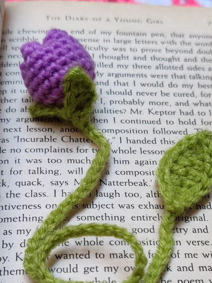 A purple tulip bookmark inside a book.