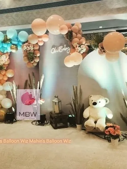 A minimalist and modern "Oh Baby" setup. The decor uses soft pastel balloons, pampas grass, and a clean white backdrop for a serene and stylish celebration.
