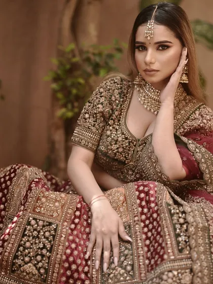 A full-length seated pose, showing the entire lehenga and the overall styling.