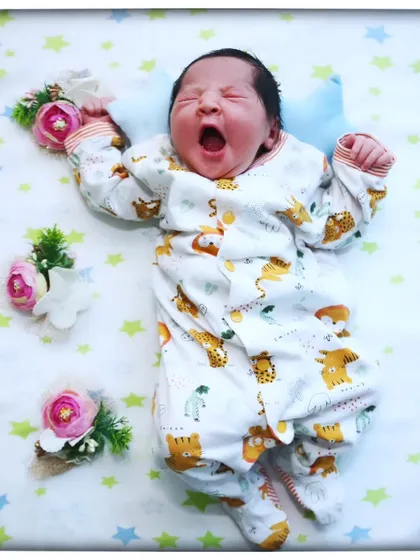 That perfect, tiny yawn. These are the fleeting moments I love to capture, freezing a memory that feels like it happened just yesterday. This little one is resting peacefully on a star-and-animal-themed blanket, ready for their first professional portrait.