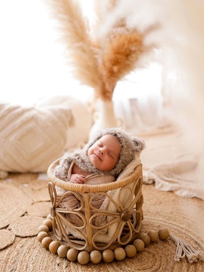 This little bear is fast asleep. Using natural textures like this woven basket and a fuzzy bonnet creates a warm, organic feel for your newborn's first portraits.