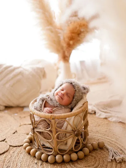 This little bear is fast asleep. Using natural textures like this woven basket and a fuzzy bonnet creates a warm, organic feel for your newborn's first portraits.