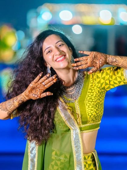 A happy bride showing off her mehndi. The joy on her face and the beauty of the henna art are what I strive for with every client.