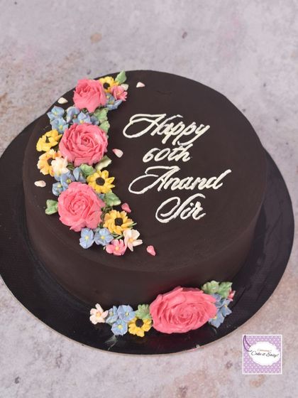 A beautiful chocolate cake for a 60th birthday, decorated with a crescent of colourful buttercream blossoms. This was a last-minute order that I was so glad I could accommodate.