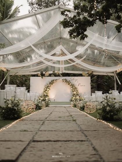 A serene and elegant all-white wedding reception theme. The clear-top tent allows guests to dine under the stars, while the minimalist decor highlights the natural beauty of the surrounding greenery at The Farmhouse Collective.