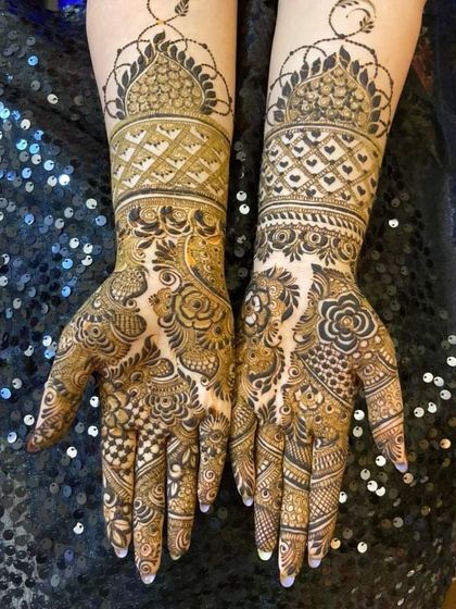 This bridal design features a prominent temple dome motif at the top, with the rest of the arm filled with intricate floral and paisley patterns.