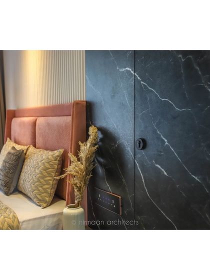 The master bedroom in our 'Atmosphere' project, showing the hidden door in the black marble wall. This is an example of how we use seamless design to conceal storage and create a clean look.