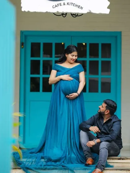 A tender moment at the "Santorini" cafe. This flowing teal maternity gown is perfect for a relaxed and stylish couple's shoot.