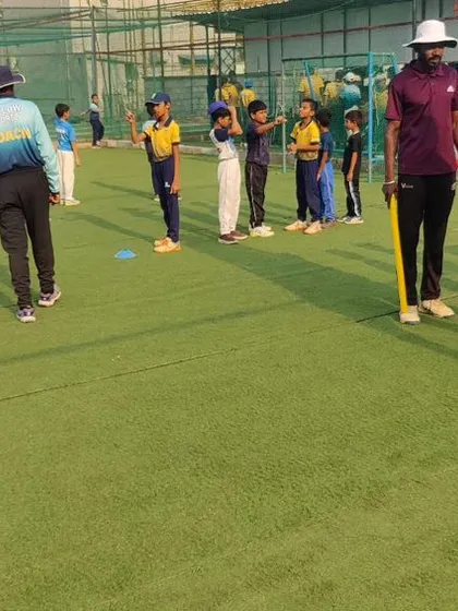 Coaches and players interacting during a break in training. We foster a friendly and supportive community at our academy.