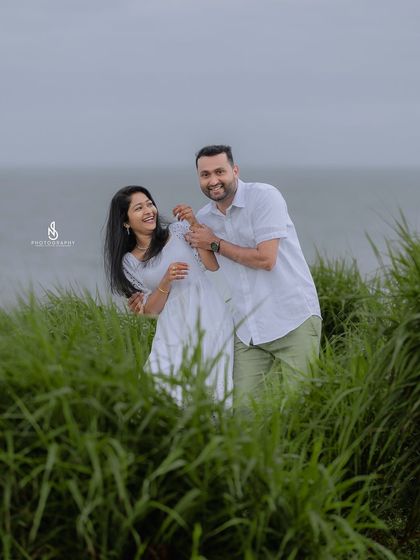 A candid moment of laughter and playfulness among the coastal grasses. These are the unscripted memories that make a photoshoot special.