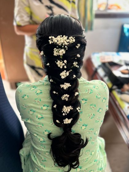 A thick, voluminous fishtail braid decorated with clusters of baby's breath. This is a gorgeous and romantic option for a Mehendi or Sangeet.
