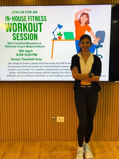 Standing by the presentation for my in-house fitness session. I'm on a mission to help people build a fitter life, one session at a time.