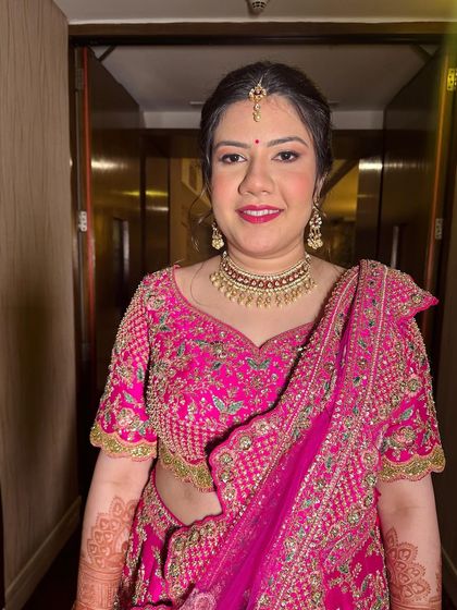 Elevating beauty with a luminous and timeless makeup glow. This client in a bright pink lehenga is ready for a wedding celebration.