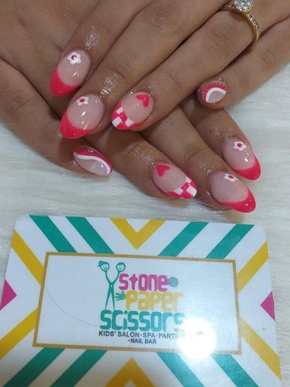 Similar to the previous set but on shorter, rounded nails, this design features a pink and white checkerboard, heart details, and a modern French tip. It's super cute and detailed.