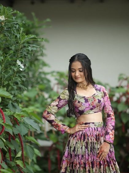 A dreamy, ethereal lehenga for the modern woman. This piece features a flowing, pleated skirt with a soft floral print, paired with a matching full-sleeve blouse for a look of effortless elegance.