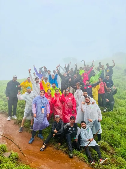 A large, happy group in colorful raincoats celebrating reaching a viewpoint on the Bandaje Falls trek. The energy and camaraderie are what make these trips special.