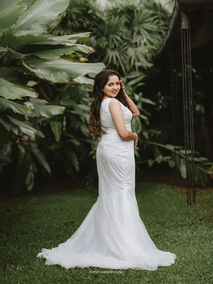 A full-length portrait of the bride, her pose elegant and her smile happy, showcasing her beautiful gown.