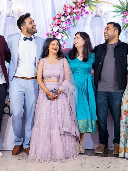 The couple surrounded by their laughing friends on stage. These are the people who make the celebration complete.