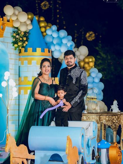 Another family photo from the twins' royal celebration, posing in front of a blue castle backdrop.