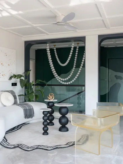 The Evelyn lounge is a sanctuary of modern design. The clean lines of the architecture are softened by the curved sofa and the organic forms of the side tables, creating a balanced and harmonious space.
