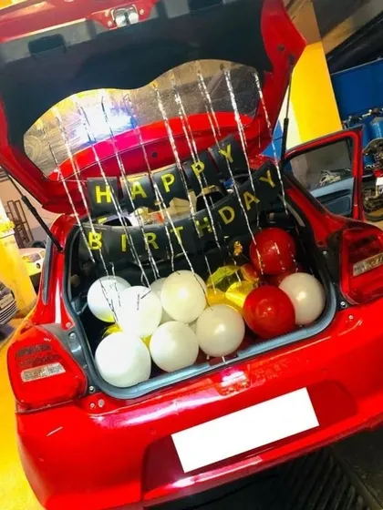 A birthday surprise on the go! A car boot filled with balloons and a 'Happy Birthday' sign is a fun and unexpected way to celebrate.